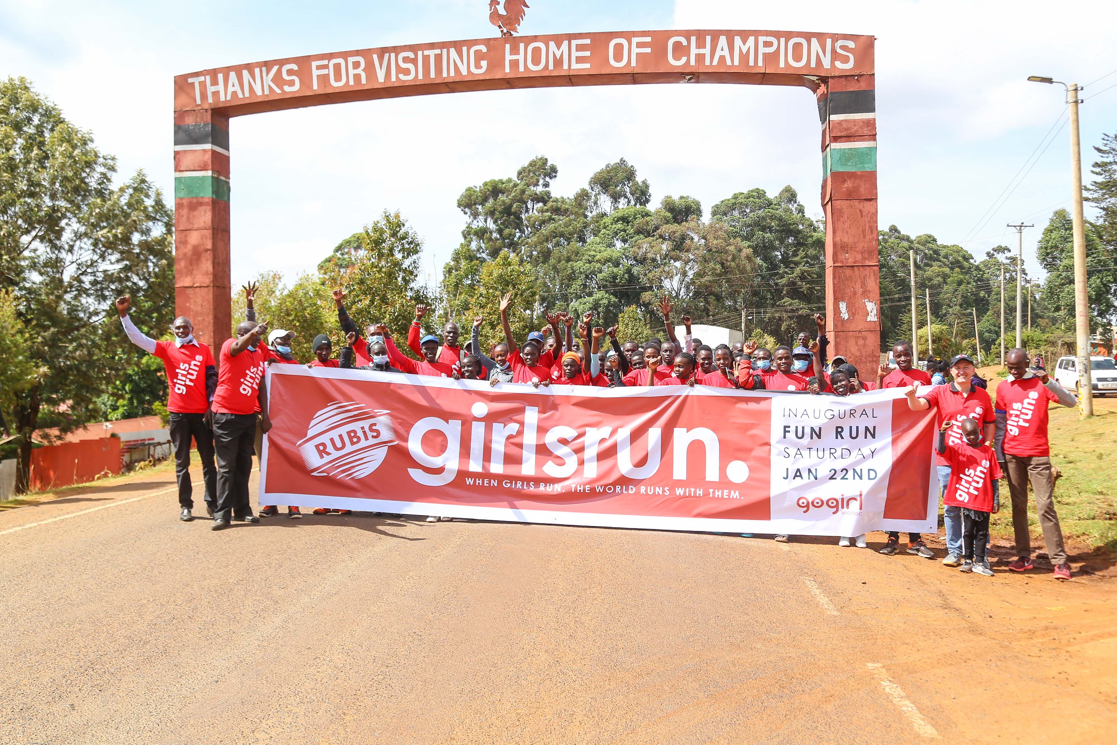 Girls at Eldoret stadium holding the "GirlsRun Marathon" banner with Rubis Kenya staff. This marathon is sponsored by Rubis Kenya